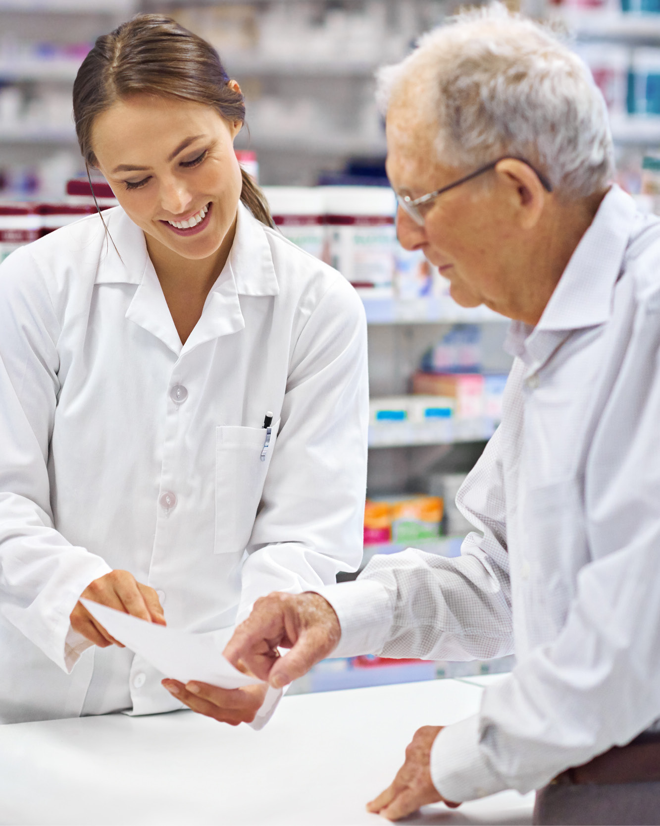Pharmacist assisting an older patient at a community pharmacy, highlighting patient support and access to care